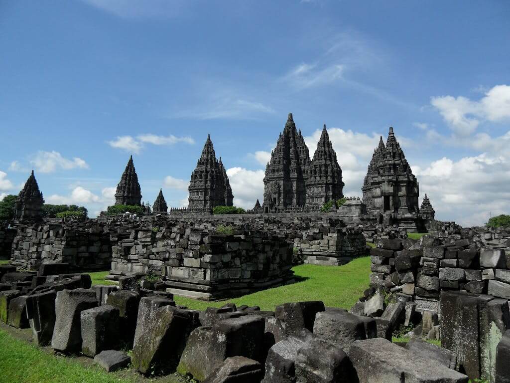 Explore the ancient Prambanan Temple in Central Java, Indonesia, with stunning stone architecture against a clear blue sky.