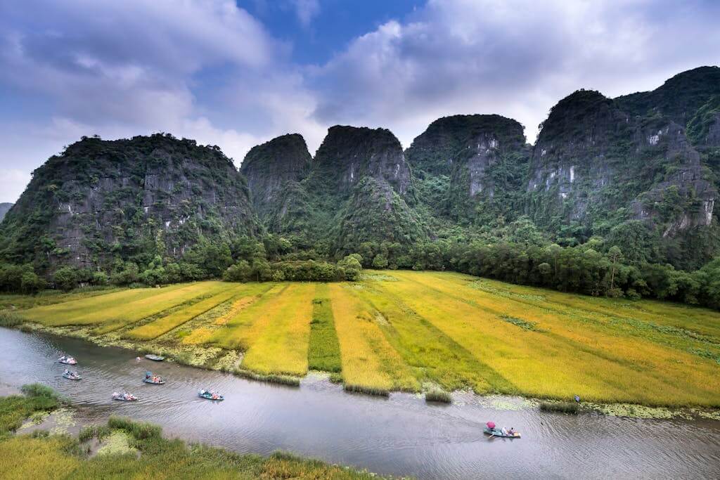 Serene landscape featuring boaters on a river with towering limestone mountains